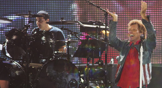 Jon Bon Jovi mostra empolgação, com o baterista substituto (ops, não era pra mostrar!) ao fundo 