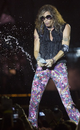 Steven Tyler brinca jogando água sobre a plateia