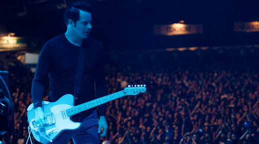 Jack White com a guitarra em punho e a multidão no Lollapalooza vibrando com o show ao fundo