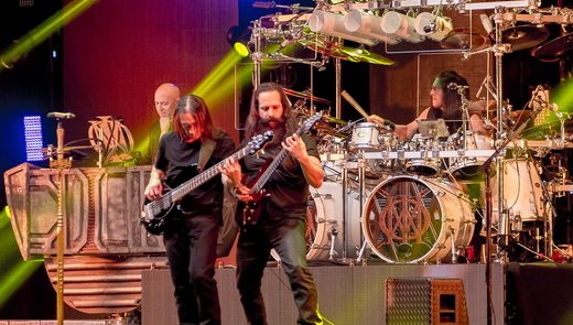 Myung e o guitarrista John Petrucci evoluem no centro do palco; teclado e bateria compõem o cenário