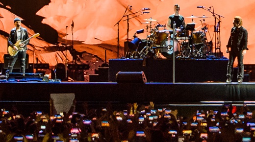 O guitarrista The Edge, o vocalista Bono Vox e o baterista Larry Mullen Jr., no centro do palco